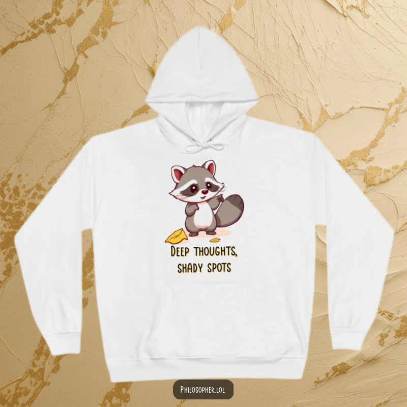 Funny hoodie with a mischievous raccoon pointing excitedly at a fallen leaf, looking for profound meaning. Cozy and humorous. Gift.