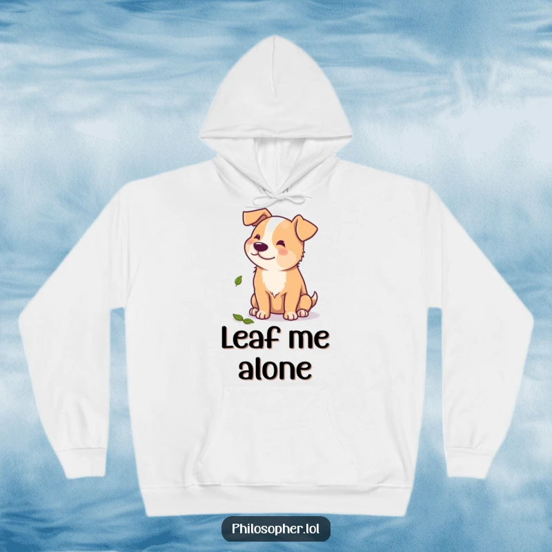 Funny hoodie with a beaming dog contemplating a single fallen leaf, a cozy and comical depiction of autumnal reflection.